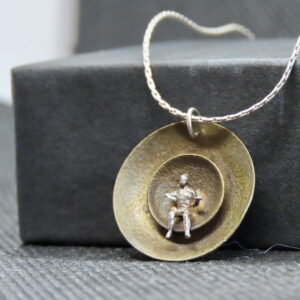 Mixed Metal. One-of-a-kind, Artisanal, Brass concave "planets" with cast sterling human figure w/ 18" silver chain.
