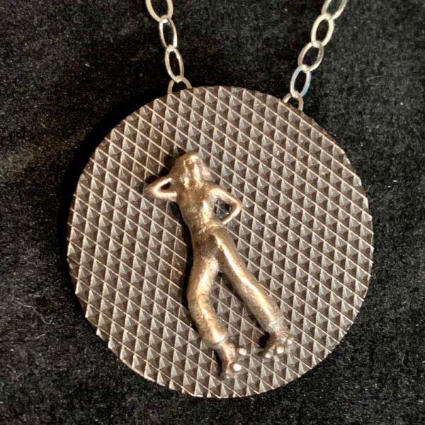 Tiny Tales. Bronze human figure on textured brass background. Sterling silver chain.