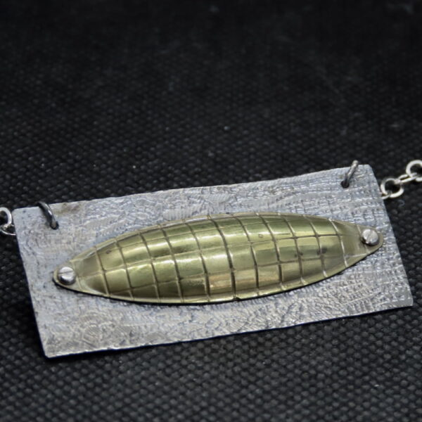 One-of-a kind, mixed metal, textured, polished brass elongated dome, micro-bolted onto textured sterling silver back. 24" silver chain