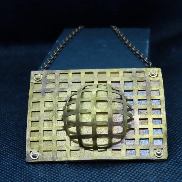 Perforated architectural brass, domed and affixed to a brass backplate. 22" Antiqued brass chain.