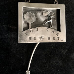 Kinetic (moving) oxidized sterling Tiny Tales figure in frame, with the message: “You can run but...”. Figure moves across the frame to behind the tree. Cubic zirconium stone at end of swinging pendulum.