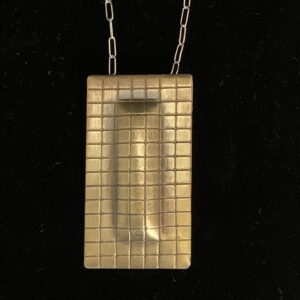 Handcrafted. Textured, domed polished brass. Sterling chain.