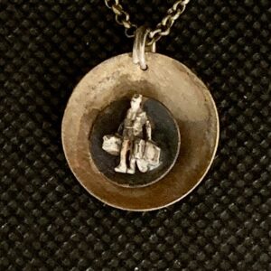 Double concave oxidized brass discs; Tiny Tales. One-of-a-kind silver miniature person (man) with suitcases; 18" chain